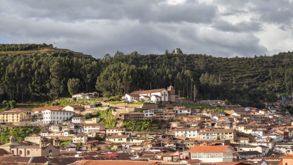 Charming view of Cusco city with its traditional architecture against a lush green hillside.