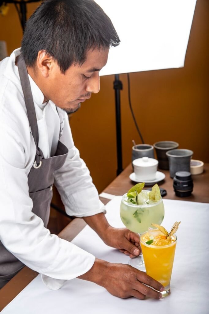 Bartender arranging colorful cocktails with a focus on presentation indoors.